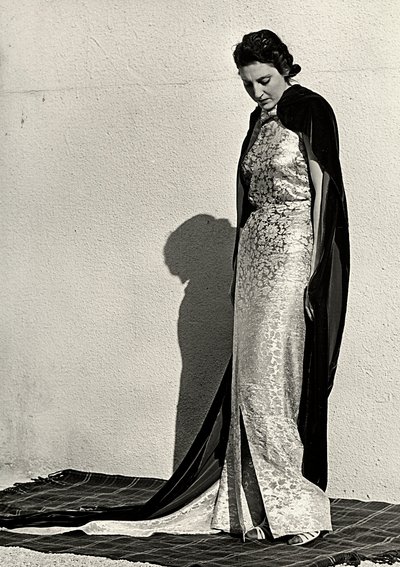 Modelo em vestido de noite criado pela casa de alta costura italiana "Dragoni". O artigo é complementado por um longo manto de veludo (foto a p/b) de Luis Bogino
