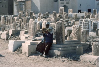 Homem iemenita recita o Corão num cemitério com túmulos em Sayun, Hadramawt, no Sul do Iémen. de Lynn Abercrombie