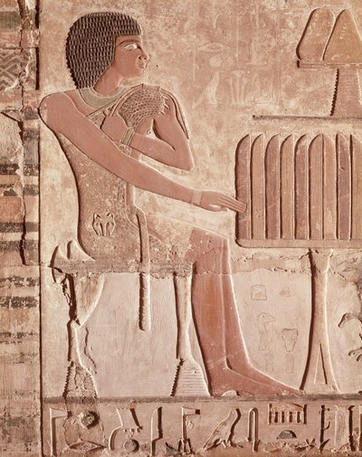 Relevo retratando o falecido sentado diante de uma mesa de oferendas com pão (pedra pintada) de Old Kingdom Egyptian