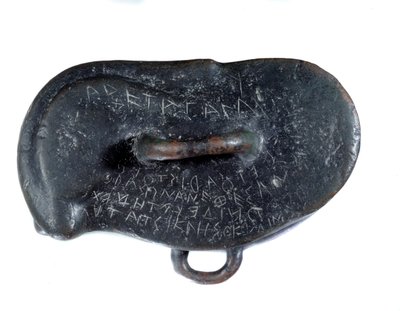 Peso votivo em bronze na forma de um osselet com uma dedicatória em grego a Apolo de Didymus, votivo ao templo do deus em Miletus. Período de Rotenide. Relatório como pilhagem por Dario I. encontrado no local de Susa. Paris. Museu do Louvre. de Persian School