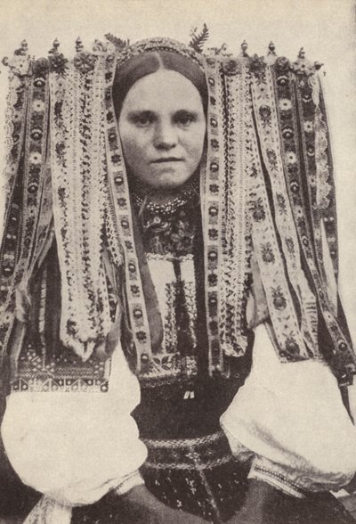 Mulher tcheca usando um cocar de fitas onde cada fita denota um pretendente que ela recusou em casamento (foto a p/b) de Photographer Czech
