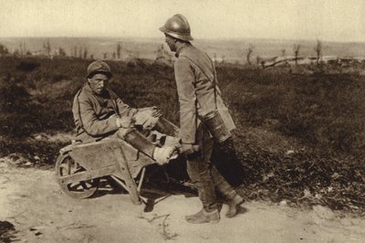 Soldado francês capturado a transportar o seu camarada ferido num carrinho de mão, na Primeira Guerra Mundial. de Photographer German