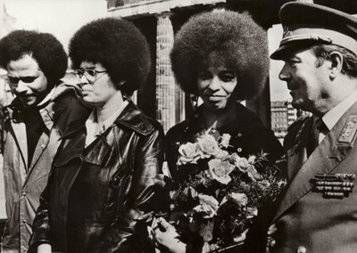 Em 11 de Setembro de 1972, a corajosa defensora americana dos direitos civis e comunistas Angela Davis foi cordialmente recebida pelos soldados do Exército Nacional Popular da República Democrática Alemã no Portão de Brandenburgo (foto a p/b). de Photographer German