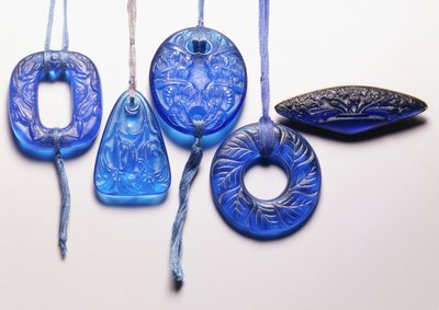 Quatro pingentes de vidro turquesa e um broche de vidro de metal dourado, de Rene Jules Lalique