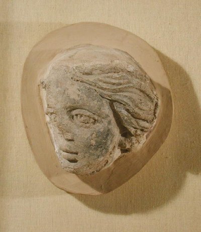 Relevo retratando a cabeça de uma mulher, da Tunísia (estuque) de Roman