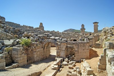 Vista através da entrada abobadada do teatro Xanthos no fosso da Orquestra, mostrando pilar e túmulo de Harpia, Xanthos, Turquia (foto) de Roman