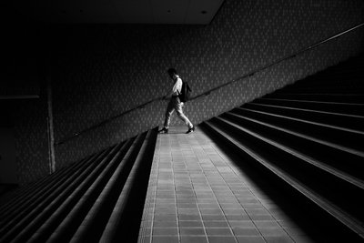 Homem numa escadaria geométrica de Satoshi Hata