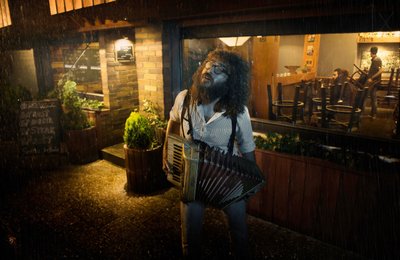 Músico numa Noite Chuvosa de See Plus
