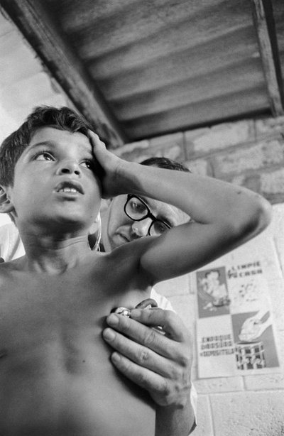 Médico americano usa estetoscópio para diagnosticar uma criança equatoriana doente no navio-hospital SS Hope de Ted Spiegel