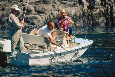 Um pescador, registando em filme a sua captura, pesca um salmão na enseada de Bute. de Ted Spiegel