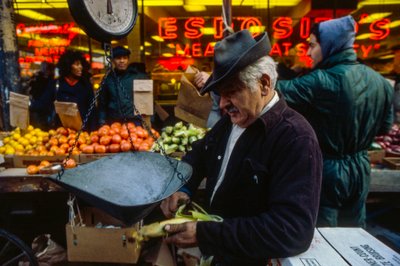 Homem a descascar uma espiga de milho no mercado, Filadélfia de Ted Spiegel