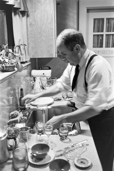 O Reverendo Lincoln Reed lava a loiça na cozinha depois do jantar de domingo em família de Ted Spiegel