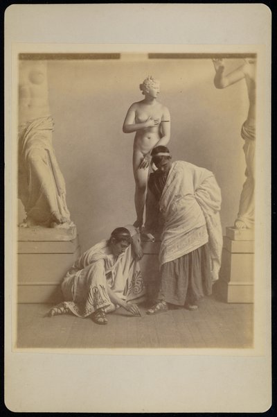 [Dois estudantes do sexo masculino em traje grego diante de um molde de gesso de Afrodite na sala de gesso da Academia da Pensilvânia] de Thomas Eakins