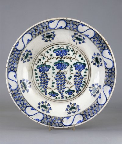 Um prato de cerâmica Iznik, com um roundel central representando três cachos de uvas e folhas de videira, c.1570 (cerâmica) de Turkish School