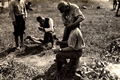 Prisioneiros austríacos durante a Primeira Guerra Mundial em Bagnaria Arsa, Udine, Itália; em primeiro plano, um soldado rapa um companheiro de soldado, 02/04/1916 (foto a p/b) de Ugo Ojetti