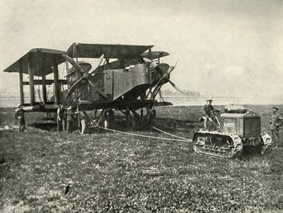 Um pequeno trator a motor colocando uma enorme máquina de bombardeio da RAF em posição ..., 1919. de Unbekannt