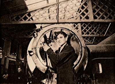 Um trabalhador de metal com broca automática descascando uma carcaça de motor, 1940 de Unbekannt