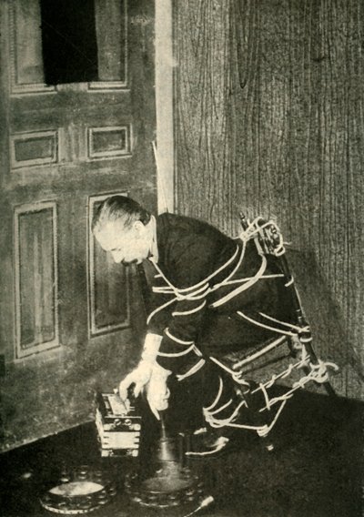 John Nevil Maskelyne realiza uma ilusão de gabinete espiritual, c1910. de Unbekannt