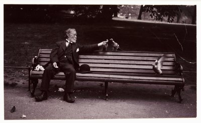 Homem num banco de jardim, c 1920 Uma fotografia de um homem sentado num banco de jardim, alimentando pombos, tirada por um fotógrafo desconhecido em cerca de 1920 de Unbekannt