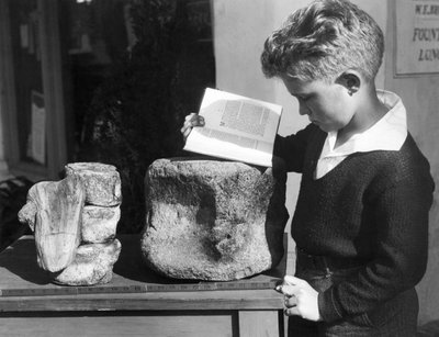 Palos Verdes, Califórnia: c.1927 Um menino estuda arqueologia com o uso de uma vértebra pré-histórica fossilizada encontrada nas colinas próximas. (foto a p/b) de Unbekannt