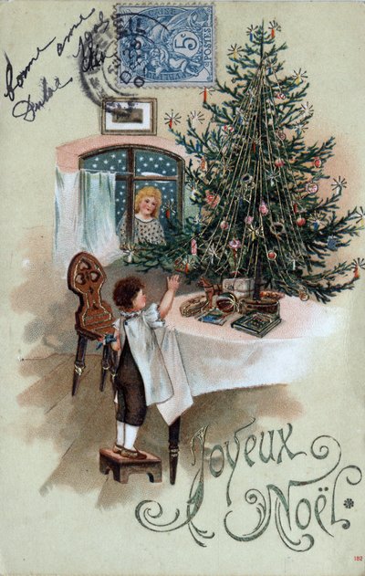 Cartão de Natal: uma criança em frente a uma árvore de Natal posa sobre uma mesa, observada por um anjo na janela - Cartão postal datado de 1905 de Unbekannt