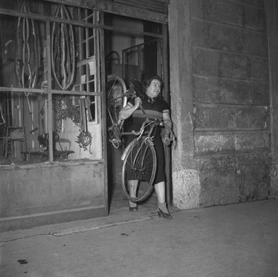 Ciclista Alfonsina Strada (Alfonsa Rosa Maria Morini) a sair da sua loja na rua Varesina 80, Milão, Itália de Unbekannter Künstler