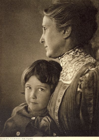 Retrato a meio comprimento de uma criança abraçada com ternura por uma senhora idosa. A mulher posa com o rosto de perfil, segurando o peito do rapazinho. Tem um olhar vivo e atrevido, dirigido para a câmara de Unbekannter Künstler
