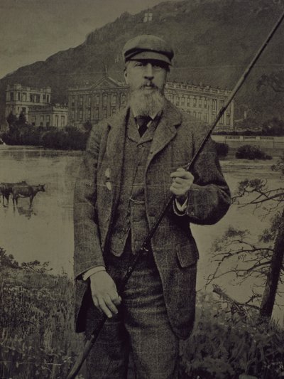 Retrato de estúdio do 8º Duque de Devonshire em tweeds segurando a cana de pesca em frente a uma tela impressa retratando Chatsworth de William M. Timlin