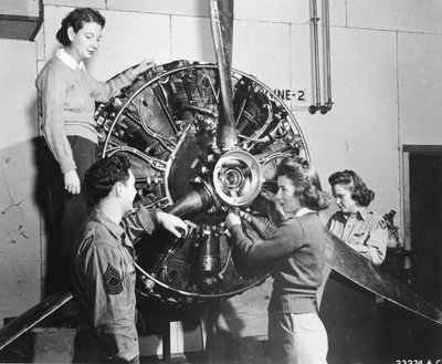 Vespas aprendem de onde vem a energia no motor B-17 Flying Fortress enquanto assistem ao treinamento de pilotos B-17 no Lockbourne AAB, trabalhando no mecanismo da hélice, enquanto um chefe de tripulação observa, eles são (l-r): Patricia Bowser, Ann Waldne de Benjamin Baud