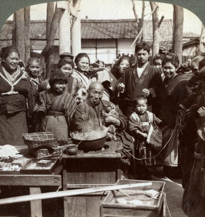 Um artista de rua com um macaco divertindo a multidão, Kobe, Japão, 1896. de Underwood and Underwood