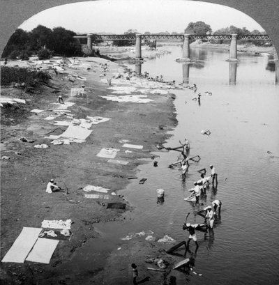 Dbobies lavando roupas no rio Goomti, perto de Lucknow, Índia, em 1900. de Underwood and Underwood