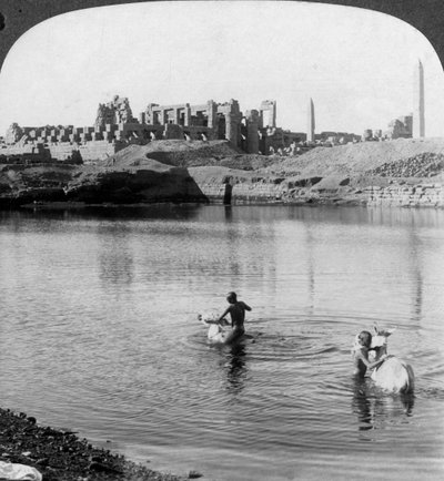Olhando do outro lado do lago sagrado para o grande templo de Karnak, Tebas, Egito, 1905. de Underwood and Underwood