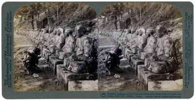 Camponês rezando diante de uma fileira de estátuas do Deus da Luz, rio Daiya, Nikko, Japão, 1904. de Underwood and Underwood