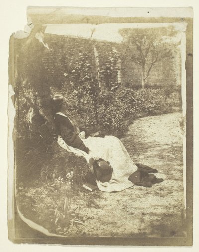 Sra. Craik reclinada no jardim com chapéu e livro de Unknown
