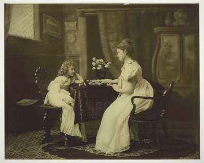 Mulher e criança jogando dominó na mesa de Unknown