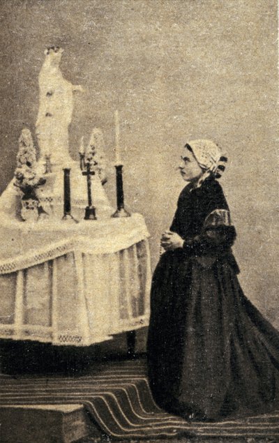 Bernadette Soubirous ajoelhada diante de um altar com a Virgem de Unknown photographer