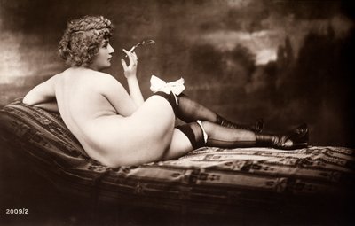 Retrato de uma jovem mulher posando nua, de costas, enquanto fuma um cigarro de Unknown photographer