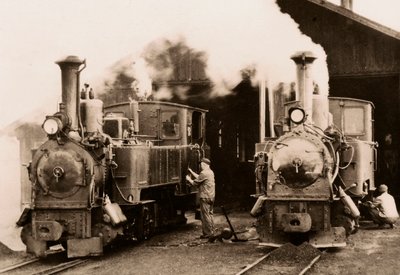 Duas locomotivas a vapor em manutenção por dois trabalhadores. de Unknown photographer