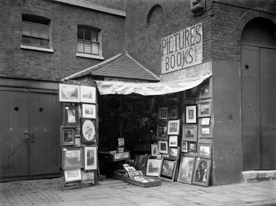 Fotos emolduradas exibidas do lado de fora de uma loja de livros e quadros de segunda mão, Londres, 1933. de WA Clark