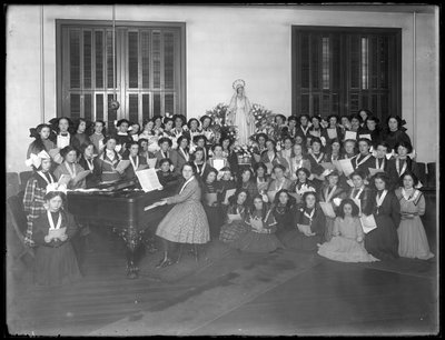 Grupo, retrato, de, um, meninas, coro, classe, juntado, ao redor, um, piano, segurando, partitura, provavelmente, em, a, católico roman, órdã, asilo, em, kingsbridge, bronx, c.1911 de William Davis Hassler