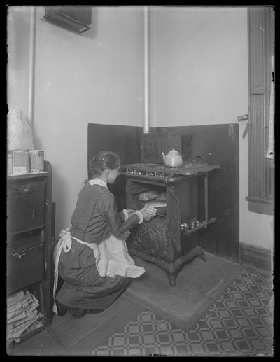 Miss Bates tirando pão do forno, c.1913 de William Davis Hassler