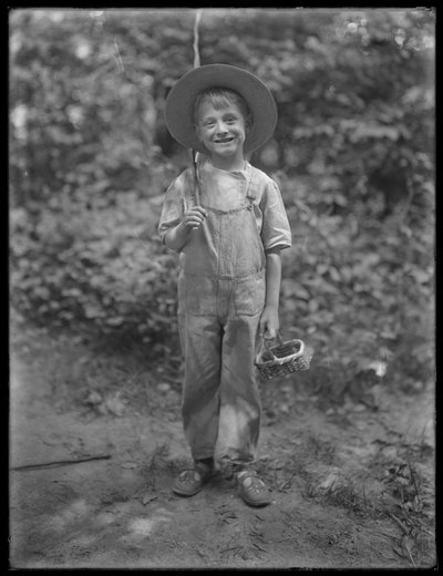 William Gray Hassler de chapéu de palha e macacão, carregando vara de pescar e cesto na floresta, 20 de agosto de 1911 de William Davis Hassler
