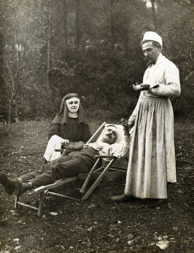 Médico medindo o pulso de um homem ferido, assistido por uma enfermeira freira, por volta de 1900 (foto p/b) de . .