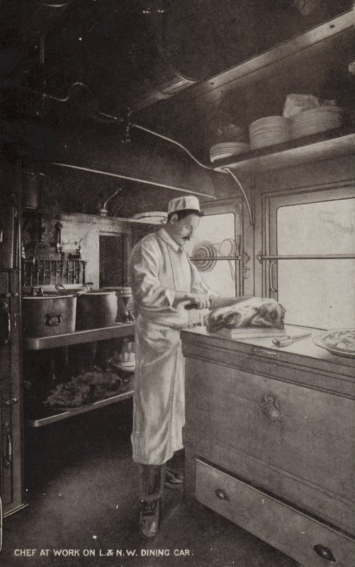 Chefe de cozinha a trabalhar em carro de jantar L e NW (foto a p/b) de (after) English photographer
