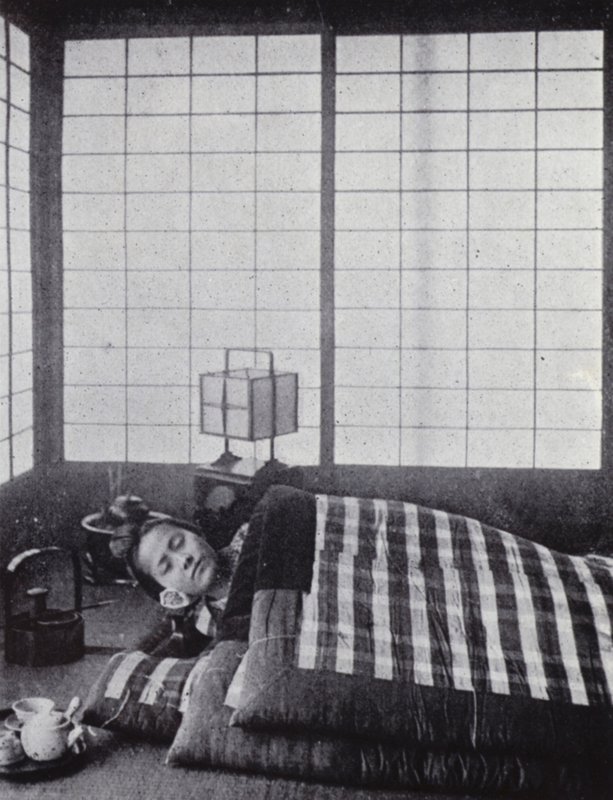 Menina a dormir entre colchas com almofadas de madeira (foto a p/b) de American Photographer (after)