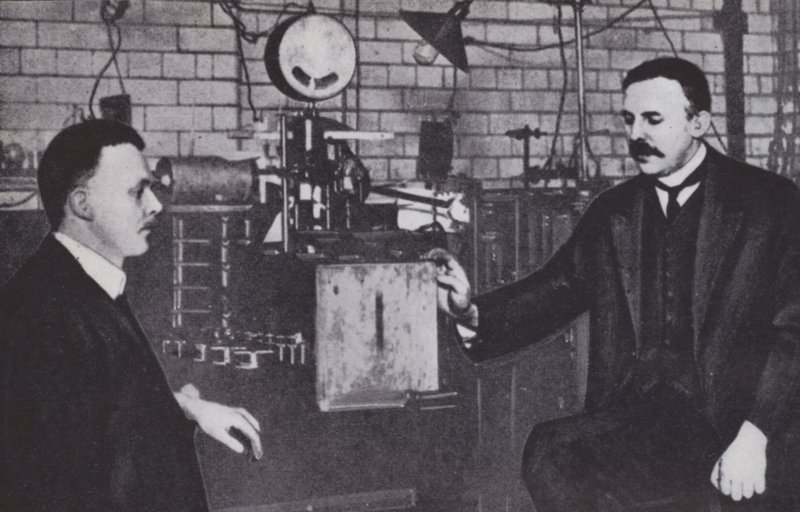 Ernest Rutherford, à esquerda, e Hans Geiger no Laboratório de Física da Universidade de Manchester (fotografia a preto e branco) de English Photographer
