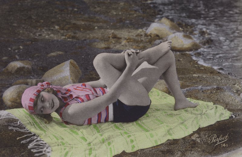 Menina deitada na toalha na praia (foto colorida) de English Photographer