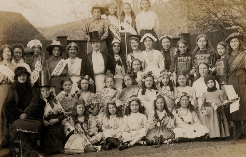 Retrato de um grupo de alunas com seus professores vestidas com trajes do mundo (foto a p/b) de English Photographer