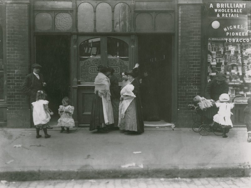 Mulheres e crianças fora de uma taverna em Londres de English Photographer