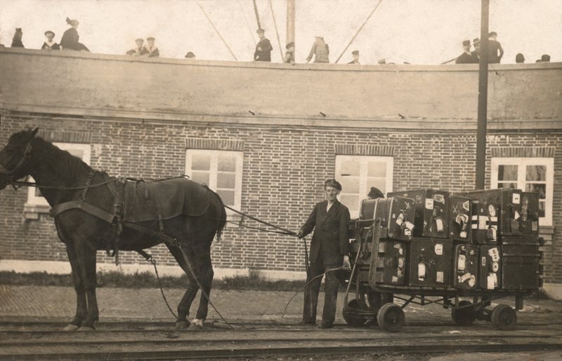 Porteiro com um carrinho de bagagem puxado por cavalos nas docas (foto a p/b) de European Photographer